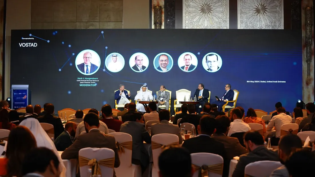 A panel on stage in front of a full room of delegates